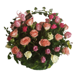 Бујна корпа од ружа различитих боја, укључујући нијансе розе, брескве, лаванде и крем, окружене зеленим лишћем. Део украсног аранжмана су и мала розе машница и честитка са „Цветним аранжманом - АРАНЖМАН СА МИНИ РУЖАМА“.